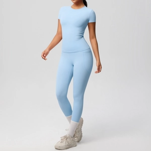 Close-up of light blue yoga set featuring a slim short sleeve top and side pocket leggings