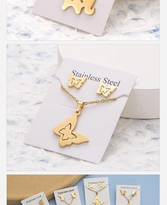 Close-up of golden butterfly necklace and earrings set on white display card