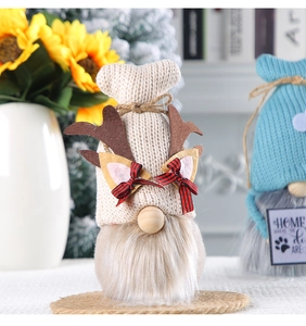 Close-up of knit Christmas gnomes with reindeer antlers and home signage decor