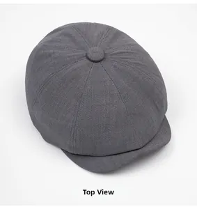 Top view of dark grey newsboy cap showing stitched multi-panel texture and top button
