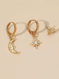 Detail view of gold star and moon earrings set with sparkling zircon inlays