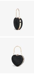 Detail view of heart-shaped rhinestone handbag with golden metal frame and handle