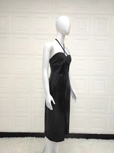 Detail of black halter neck dress featuring sequined split skirt on white mannequin