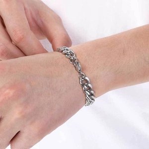 Bracelet gourmette unisexe en acier inoxydable argenté poli porté au poignet d'un modèle