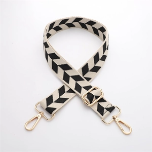 Adjustable beige woven strap with black chevron patterns and gold metal buckles