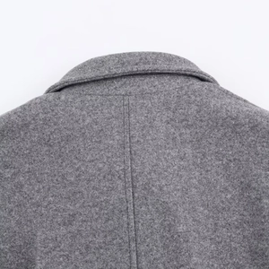 Detailed view of the gray woolen fabric texture and back seam stitching on the coat