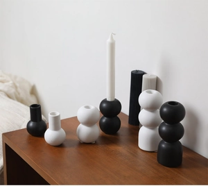 Detailed view of minimalist black and white ceramic candle holders with geometric sphere shapes