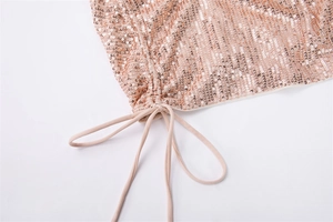 Gros plan du tissu à paillettes or rose avec cordon de serrage sur la robe moulante