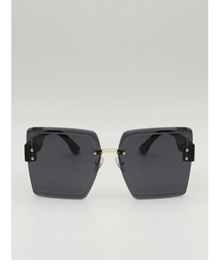 Detail of square oversized sunglasses with black lenses and gold bridge accents