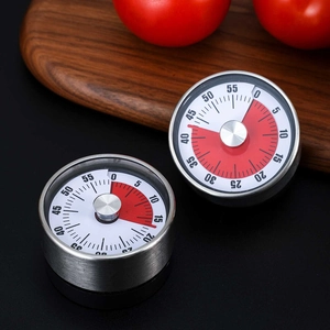 Mechanical stainless steel kitchen timer with red 60-minute dial on a wooden board