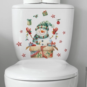 Detail eines weihnachtlichen Schneemann-Aufklebers auf einem weißen Toilettenspülkasten
