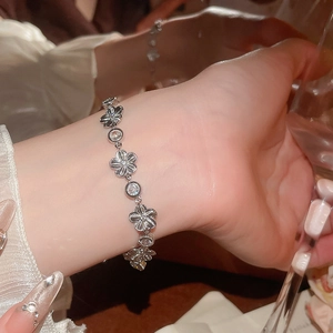 Gros plan d'un bracelet fleuri en zircon porté au poignet sous une lumière élégante