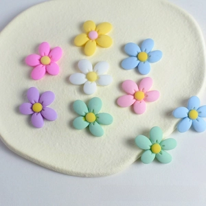 Macro shot of 3D resin peach blossom charms in assorted macaron colors for DIY crafts