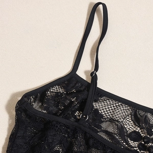Close-up of black lace texture and adjustable shoulder straps on a bodysuit