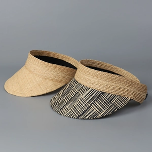 Detail of woven raffia sun hats featuring classic natural texture and geometric patterns