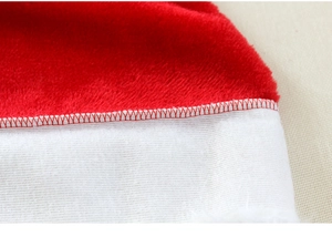 Close-up of red plush fabric and white woven material with detailed stitching on Santa hat