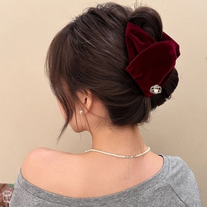 Elegant wine red velvet bow hair claw clip with pearl flower detail worn by a model