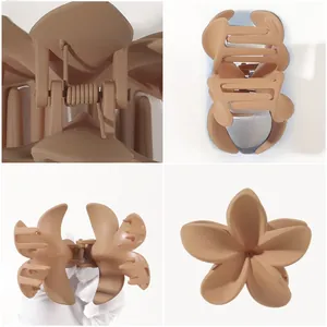 Detail of matte brown frangipani flower hair claw clip with strong metal spring