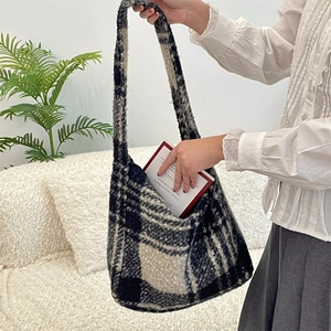 Close-up of black and white checkered plush tote bag showing soft wooly fabric texture