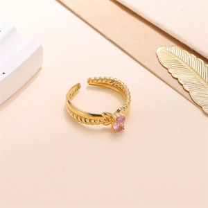 Macro detail of gold-plated open ring featuring purple oval zircon and twisted rope texture