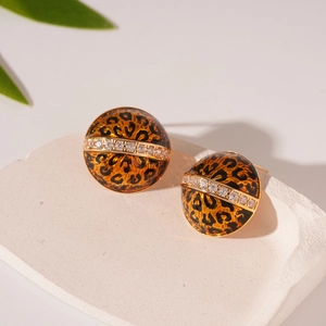 Detailed view of leopard print dome earrings with gold band and sparkling rhinestones