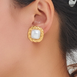 Detail of square white pearl in golden woven metal setting on a French retro stud earring