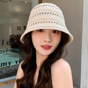 Detailed close-up of cream knit bucket hat texture on a model in urban setting