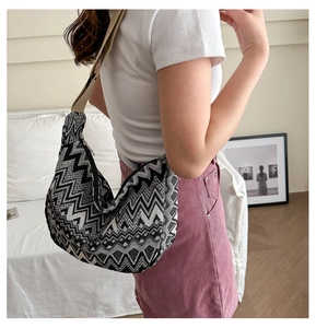 Détail d'un grand sac bandoulière en toile tissée avec motif géométrique et sangle