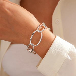 Detail of silver textured oval link bracelet featuring intricate braided metal patterns