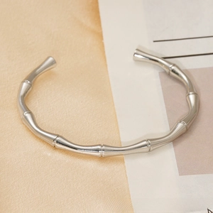 Macro detail of silver bamboo-style stainless steel cuff bracelet with polished finish