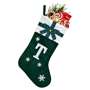 Close-up of green Christmas stocking with white snowflake patterns and embroidered letter T