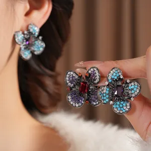 Vintage butterfly earrings with colorful zircons and black gold plating shown on model