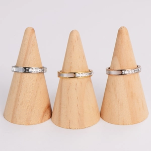 Three square shell rings in silver, gold, and rose gold finishes on wood stands