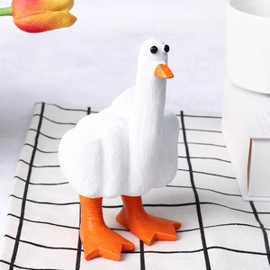 Detailed close-up of a funny white resin duck ornament with middle finger on checkered cloth