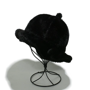 Thick black plush bucket hat for women with elegant ruffled brim on a display stand