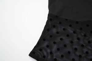 Vue détaillée du tissu en tulle noir avec des pois floqués élégants sur cet ensemble