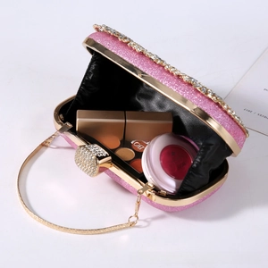 Macro view of pink sequin evening bag with gold metal frame and rhinestone clasp interior
