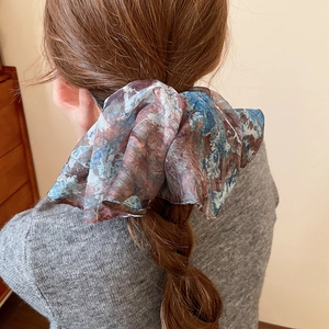 Close-up of oil painting style hair scrunchie on a ponytail with artistic fabric texture