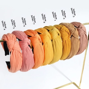 Set of 8 colorful knotted headbands in ribbed knit fabric on gold metal display rack