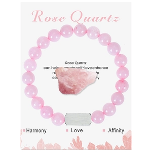 Macro detail of Rose Quartz beaded bracelet with raw stone on a white display card