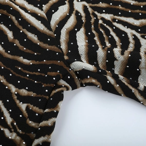 Macro view of zebra print fabric with sparkling rhinestone accents and sewing details