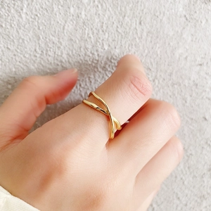 Macro shot of 925 silver irregular crisscross gold ring with hammered texture on finger