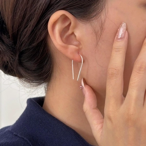 Minimalist 925 sterling silver U-shaped hoop earrings worn by a model in a close-up shot
