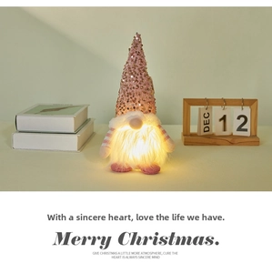 Pink sequin Christmas gnome with LED warm light decor on a cozy bookshelf