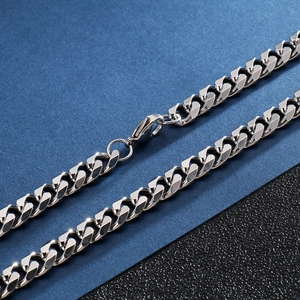 Macro view of silver Cuban link chain with lobster clasp and polished steel texture