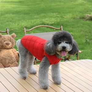 Close-up of red quilted pet vest with diamond pattern on a dog in an outdoor setting