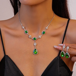 Gros plan d'une parure de bijoux vintage en argent avec pendentif goutte émeraude sur mannequin