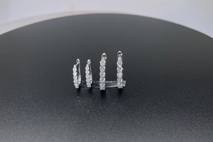 Macro shot of two pairs of 925 sterling silver hoop earrings with pave moissanite stones