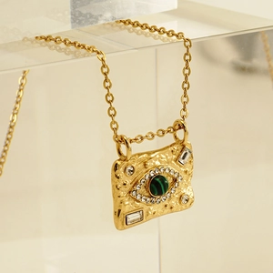 18K gold plated stainless steel necklace with malachite evil eye pendant on acrylic stand