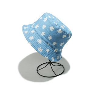Detail of light blue denim bucket hat with white maple leaf print on metal stand